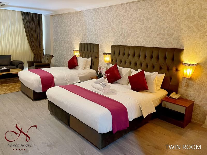 A spacious double room with two beds and elegant decor
